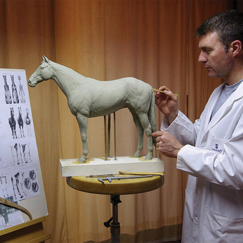 Lladro sculptor Ernest Massuet working on a detailed porcelain horse sculpture in his studio