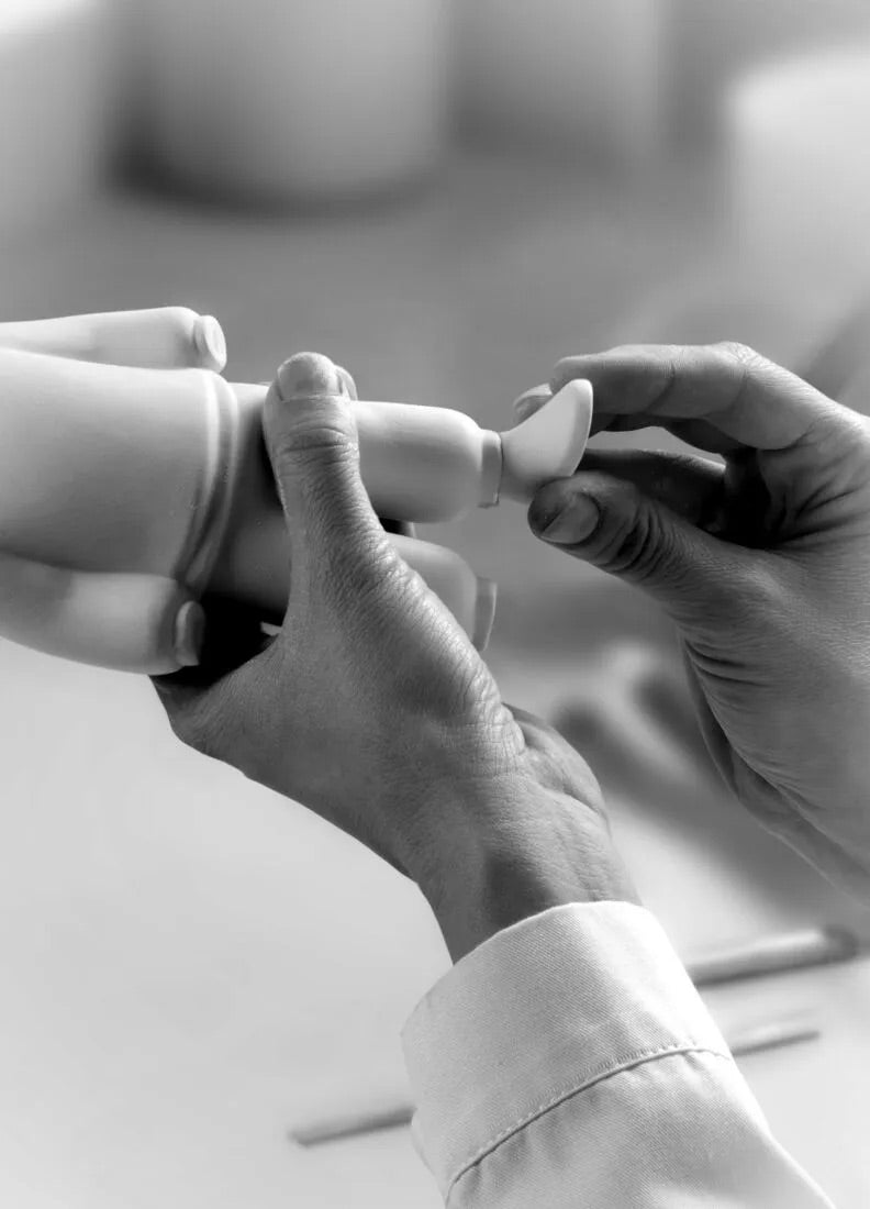 Close-up of hands holding a small white object against a blurred background