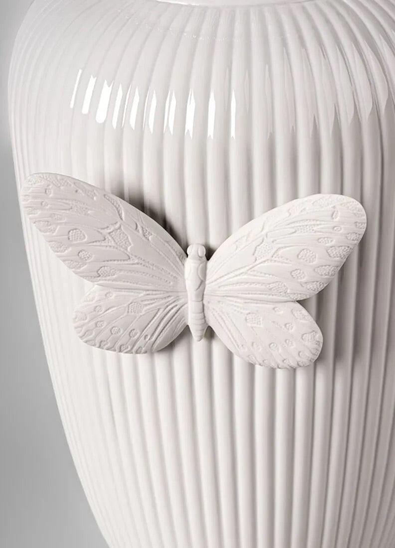 White ribbed vase with a butterfly design on a gray background
