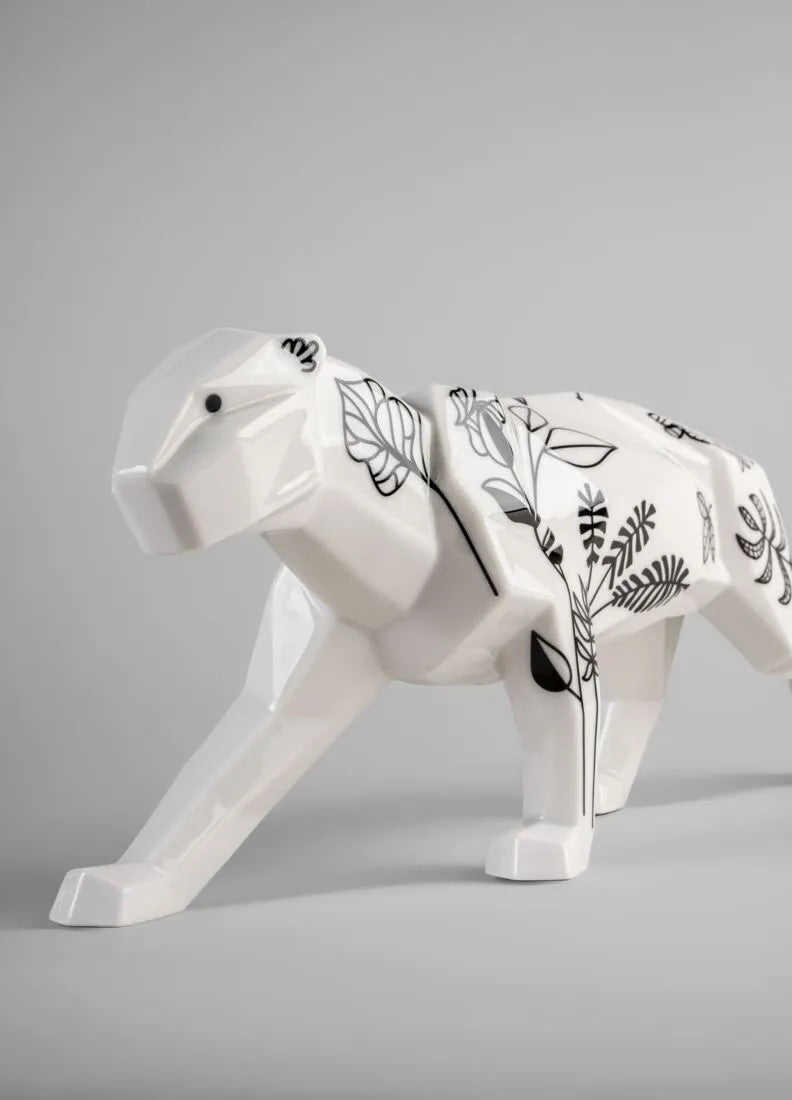 White panther figurine with black floral patterns on a gray background