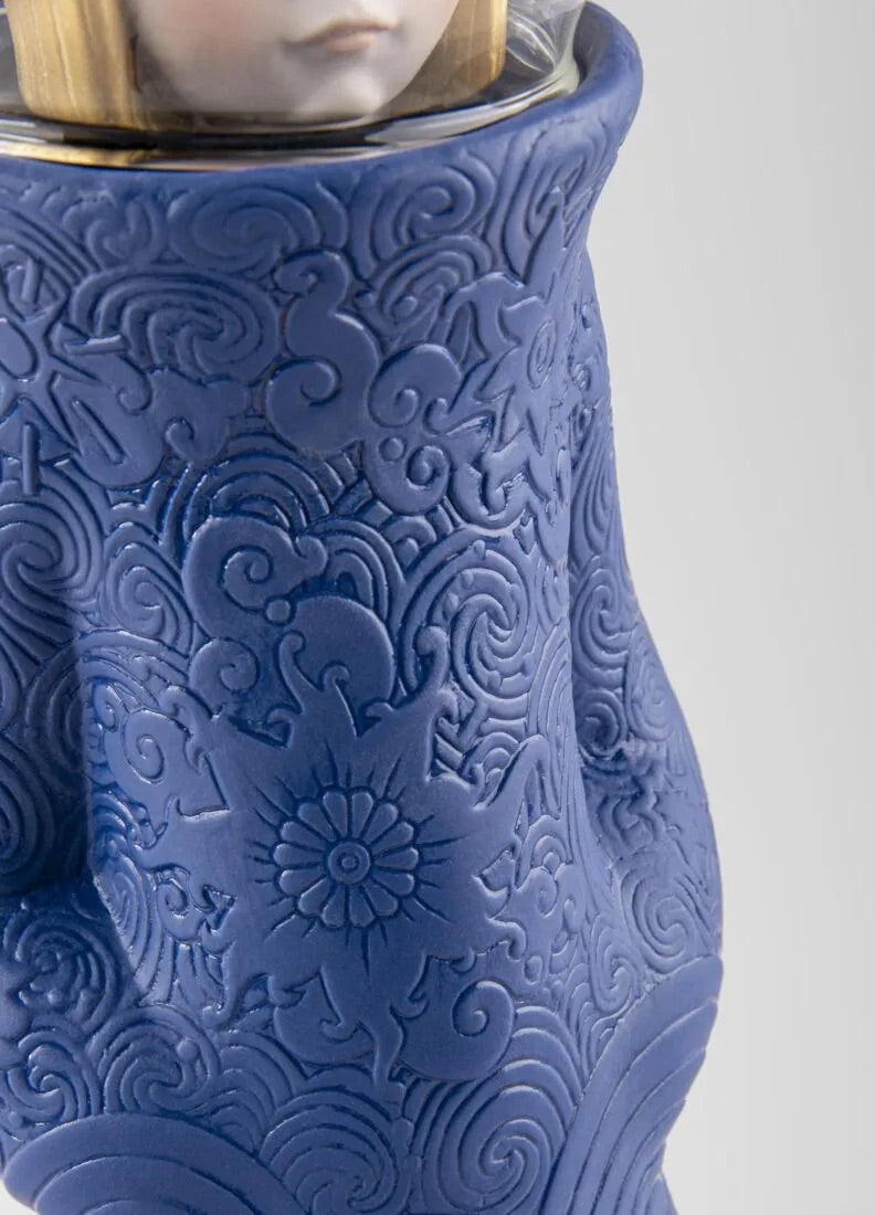 Blue porcelain figurine with intricate patterns on a white background