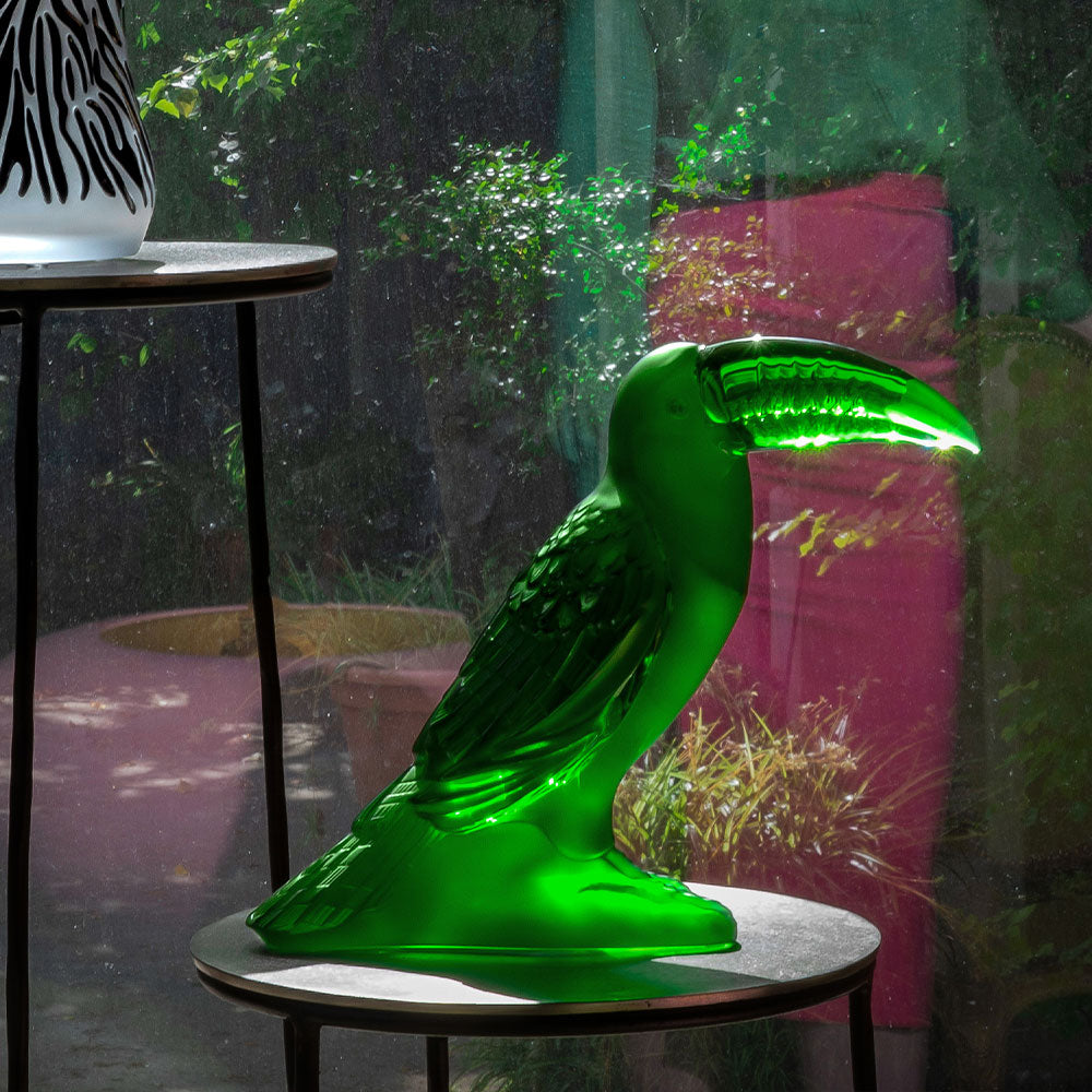 Toucan Sculpture Lalique amazon green crystal in front of greenery