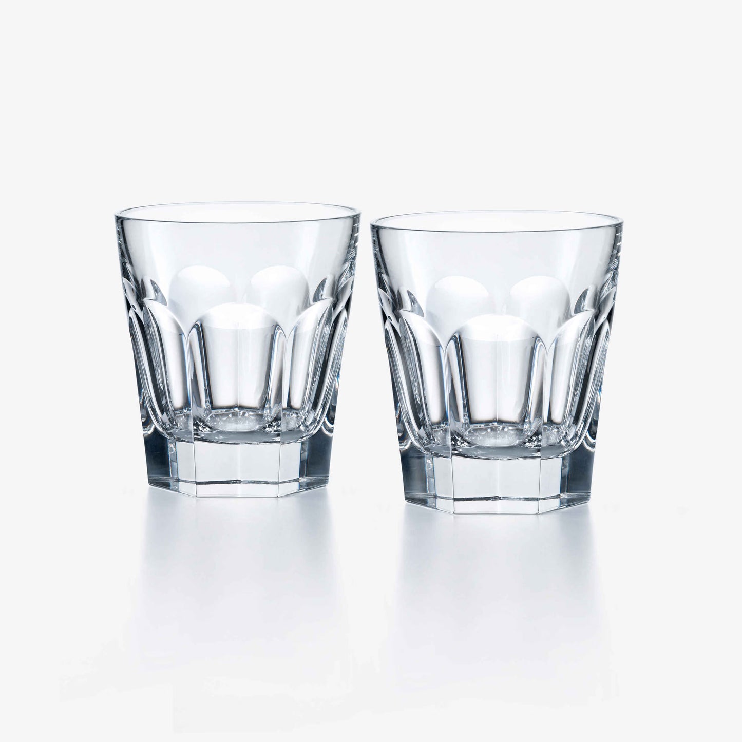 Two clear Baccarat glass tumblers on a white background