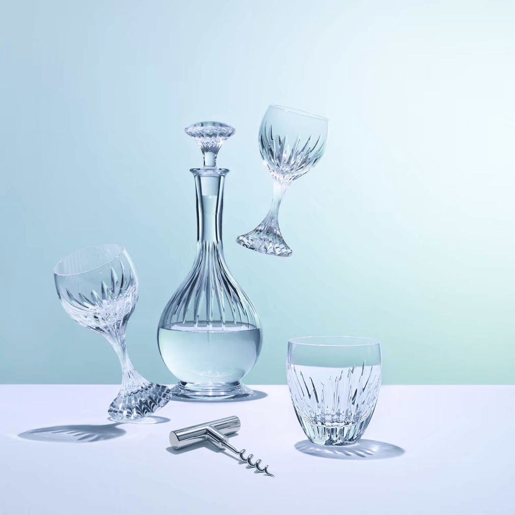 Set of crystal wine glasses and decanter on a light blue background