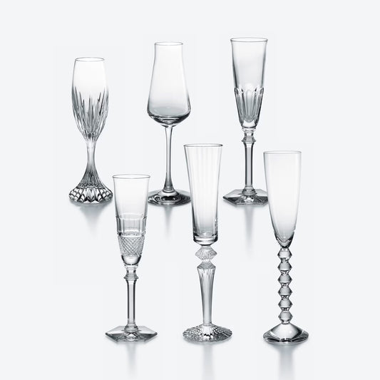 Set of six  Baccarat crystal glasses with varying designs on a white background