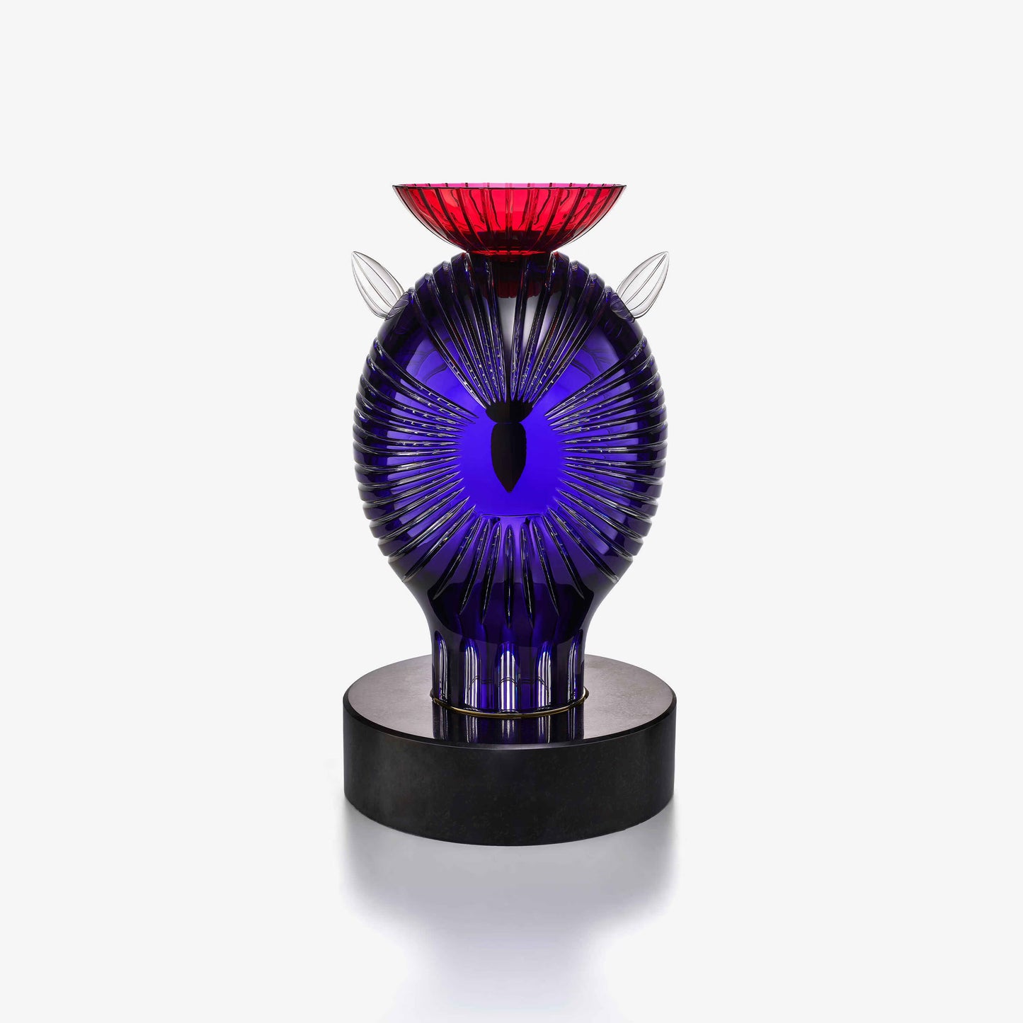 Decorative crystal sculpture with blue and red design on a white background