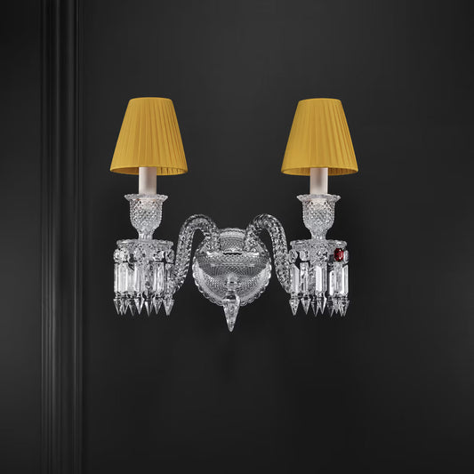 Decorative wall sconce with crystal design and yellow lampshades on a dark background