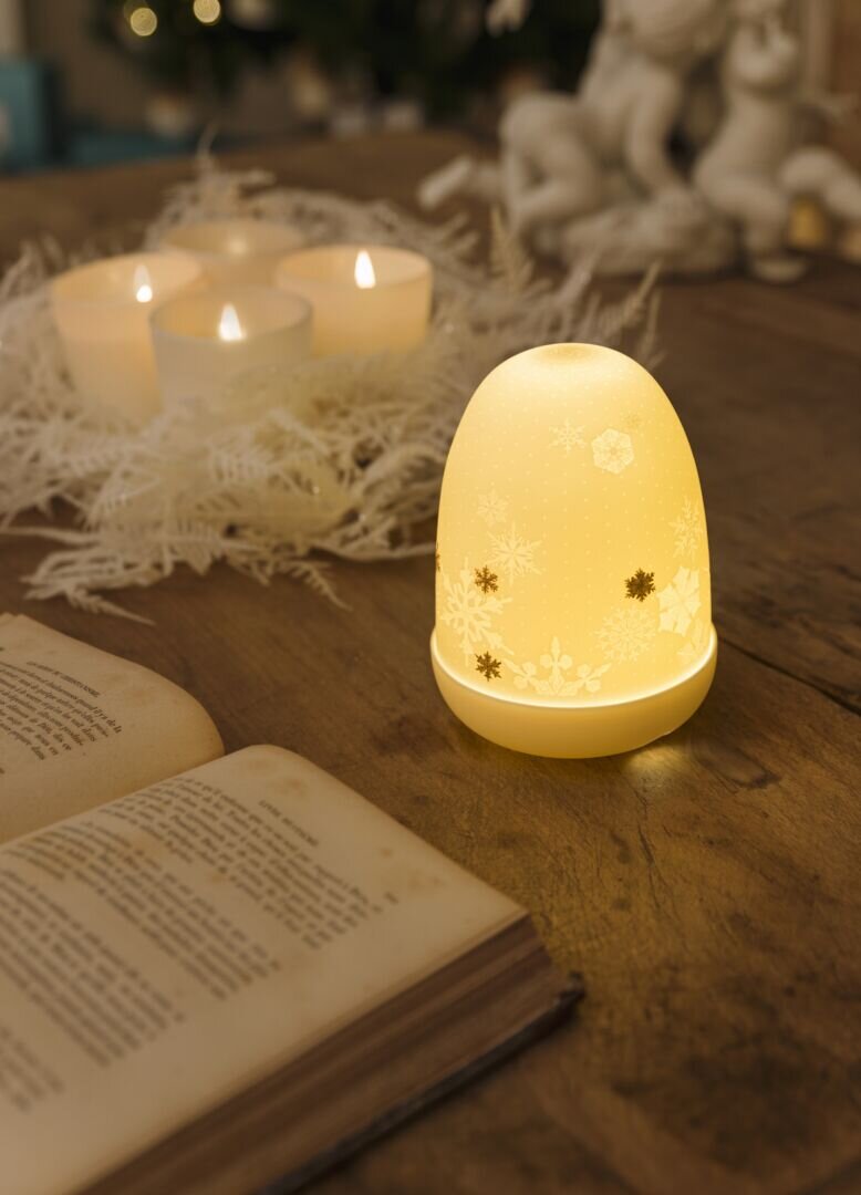 Elegant Snowflakes Dome Table Lamp with warm glow, placed beside candles and an open book, by Formfluent Sydney Australia.