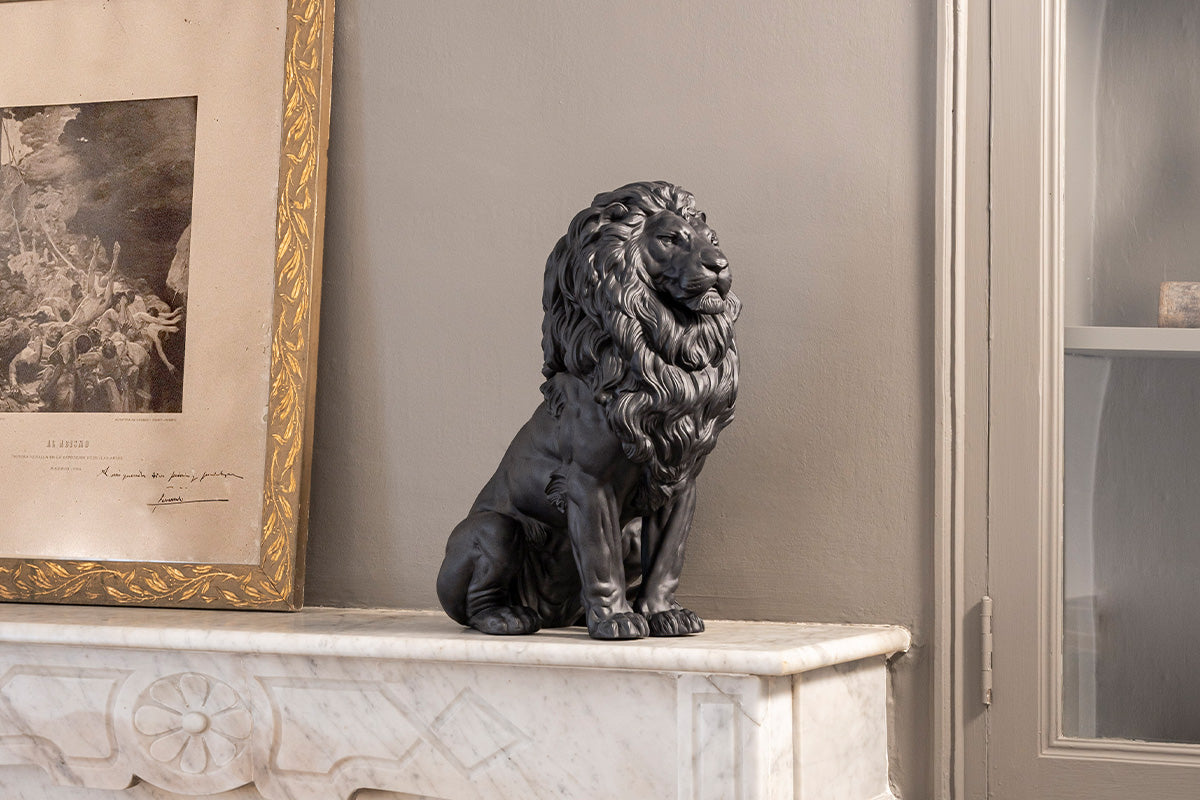 Lladró Majestic Lion porcelain sculpture in matt black on a stone table top. 