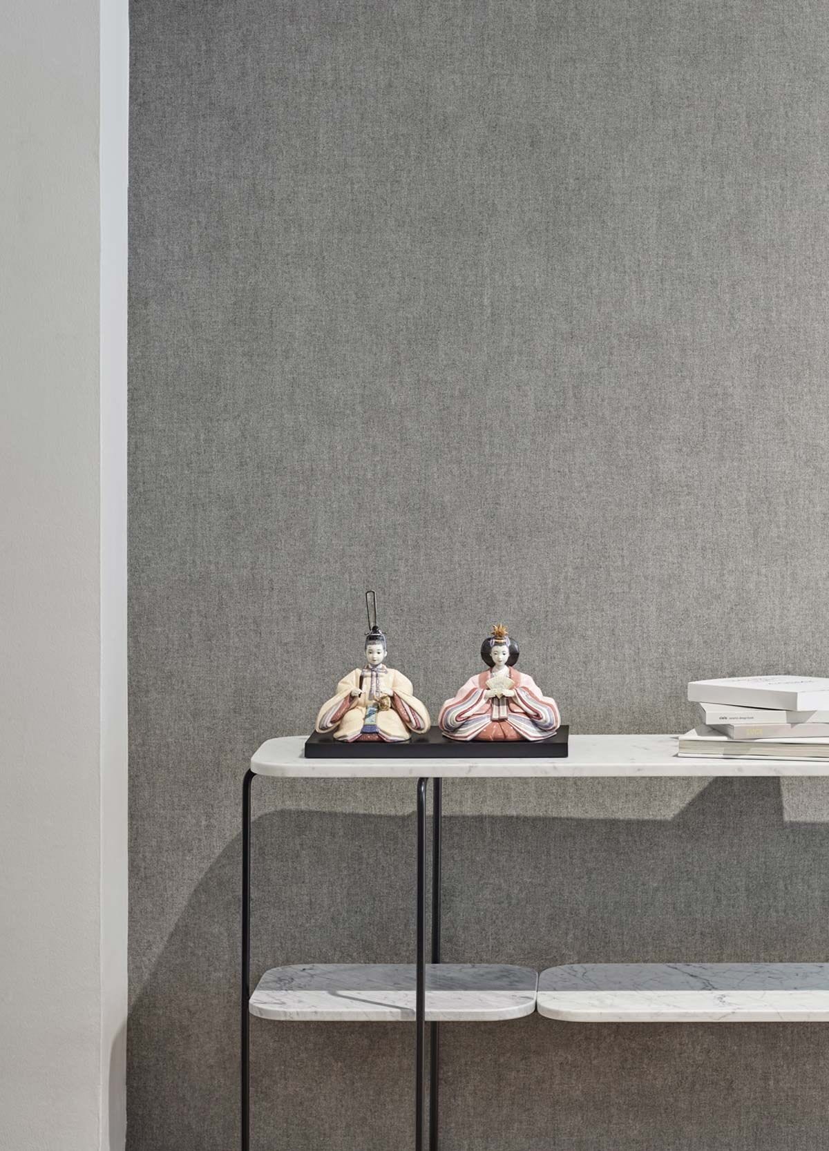 Hina Dolls figurines in beige and pink displayed on a modern shelf against a textured gray wall.