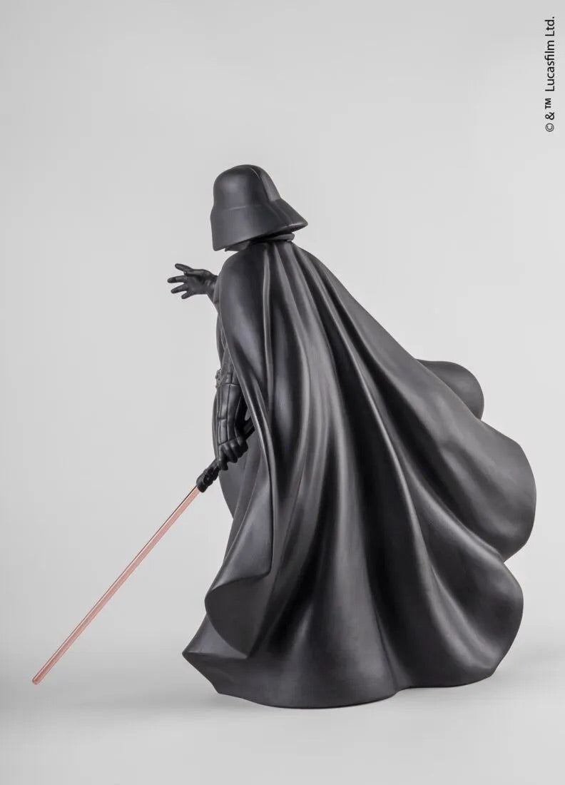 Sculpture of a Darth Vader in dark robes with a cape, holding a lightsaber, on a light gray background.