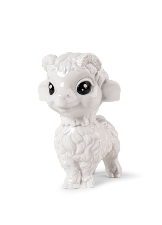 A white ceramic figurine of a cute, stylized ram or baby sheep with large black eyes, standing on a white background.