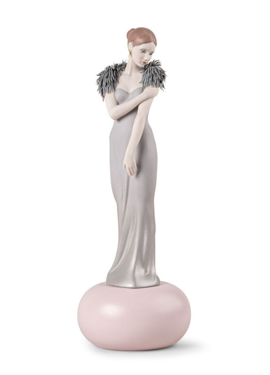 A porcelain figurine of a woman in a long gray gown with a gray feathered collar, standing on a round pale pink base against a white background.