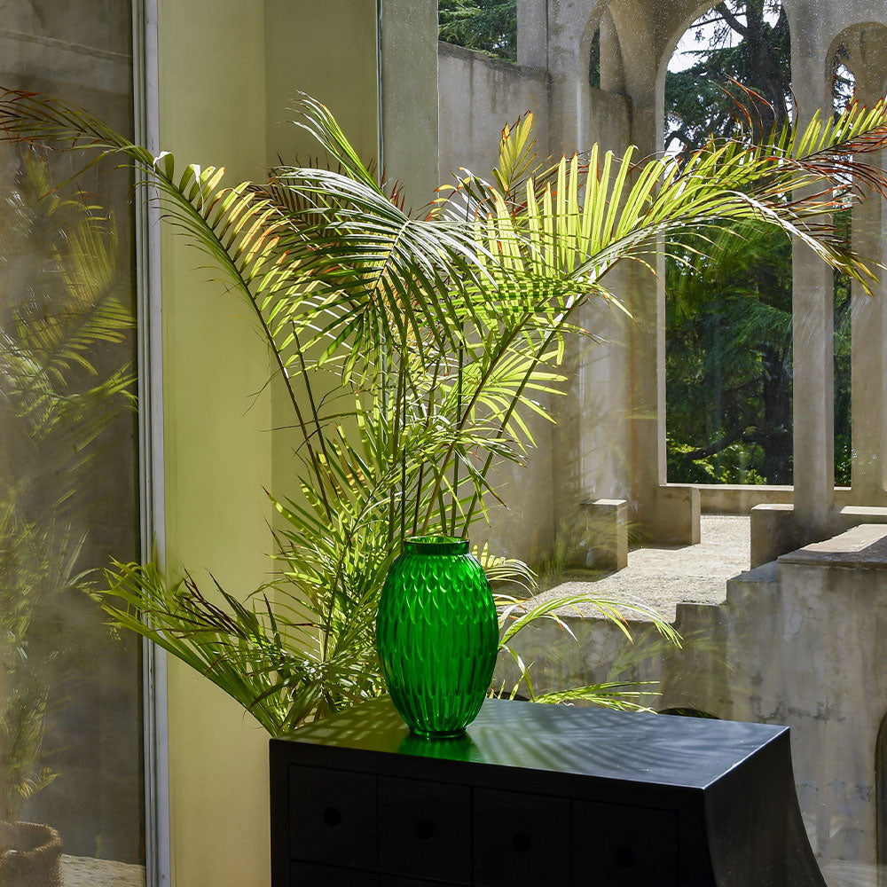 Plumes Vase Lalique green crystal in a courtyard