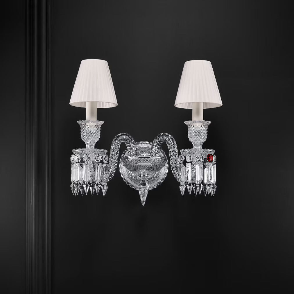 Decorative wall sconce with crystal design and white lampshades on a black background