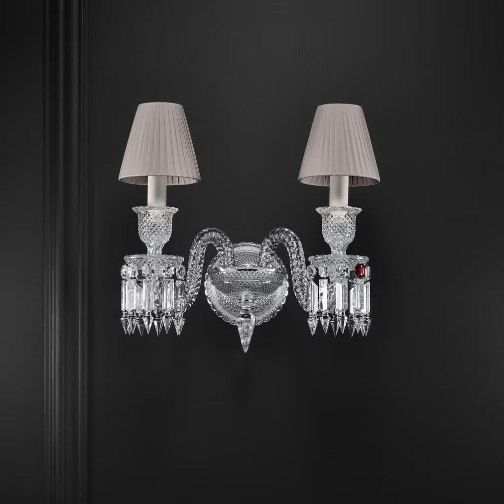 Decorative wall sconce with crystal details and two grey lampshades on a dark background