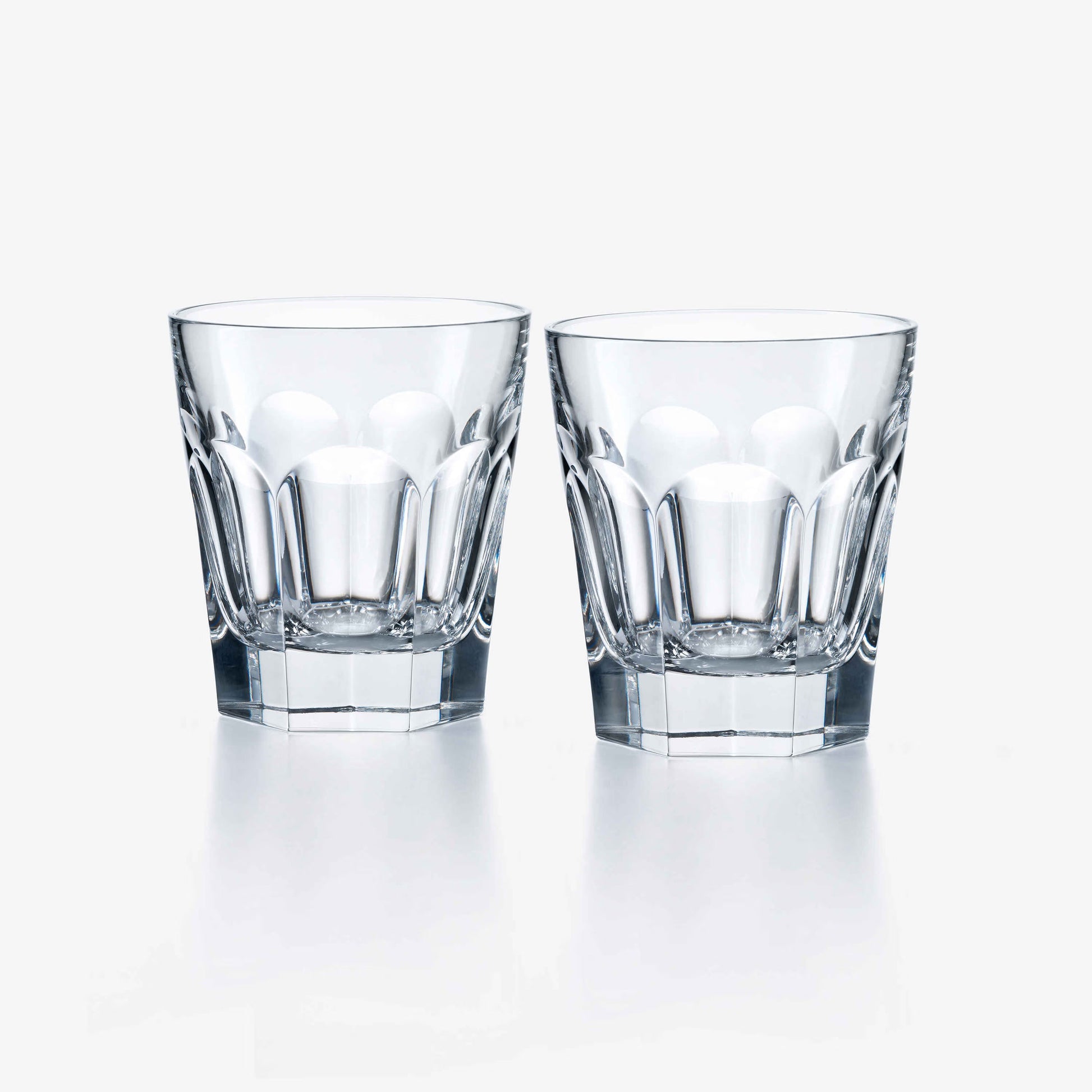 Two clear Baccarat glass tumblers on a white background