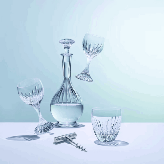 Set of crystal wine glasses and decanter on a light blue background