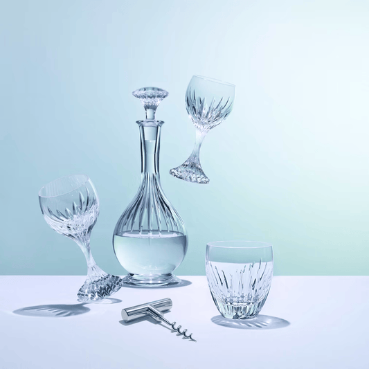 Set of crystal wine glasses and decanter on a light blue background