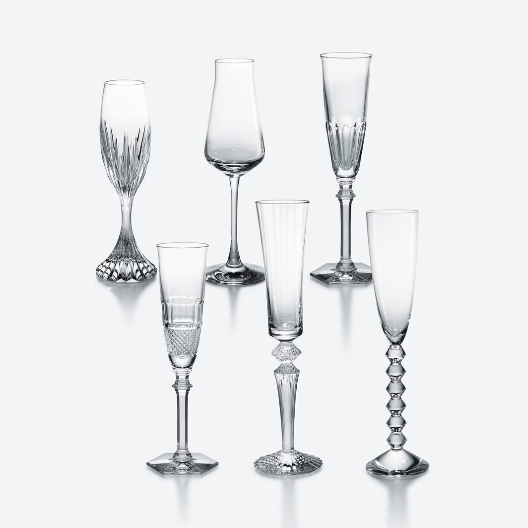 Set of six  Baccarat crystal glasses with varying designs on a white background