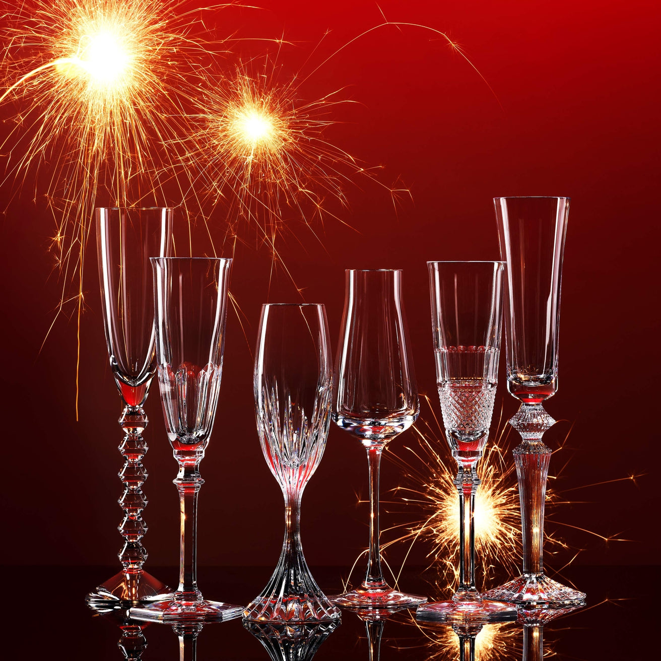 Set of Baccarat wine glasses against a red background with fireworks