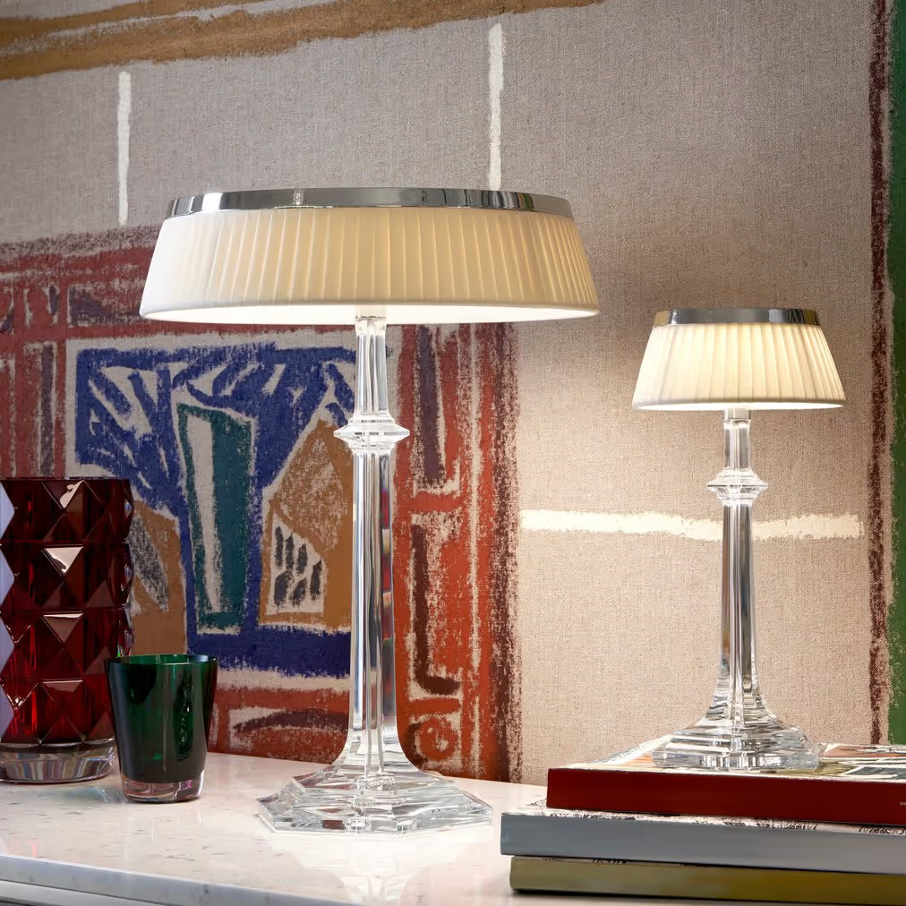Two table lamps on a surface with a textured wall in the background