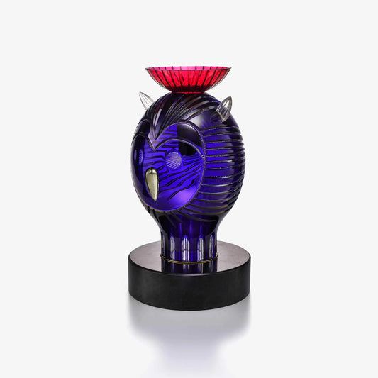 Decorative crystal sculpture with blue and red design on a white background