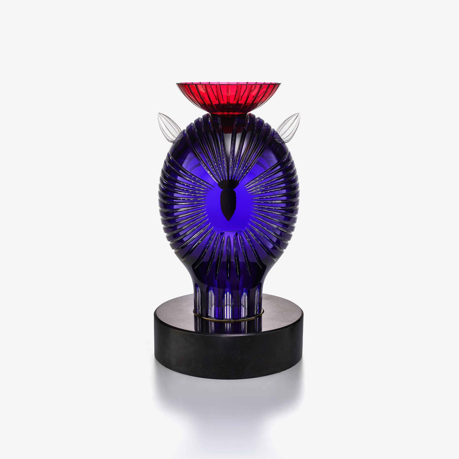 Decorative crystal sculpture with blue and red design on a white background