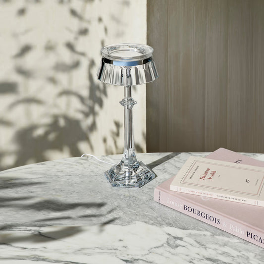 Crystal table lamp on a marble surface with books in the background